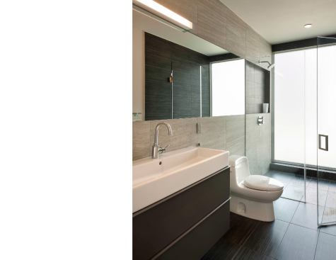 The renovated master bath features a frosted glass wall for privacy and diffused natural light.