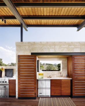 This outdoor living room in Texas Hill Country hides a full kitchen behind folding slatted Western red cedar doors. Built-ins, made from locally harvested limestone and Spanish Cedar include tip-top appliances, a screened bath area, and storage. A lean-to provides shelter from the elements. 
Project: Story Pool House, Centerpoint, Texas; Architect: Lake|Flato Architects, San Antonio; Builder: Duecker Construction, Stone Wall, Texas