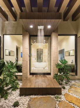 Beyond the master suite's private patio, a glass door gives way to a trellised outdoor shower that, in turn, opens to an indoor shower and the rest of the master bath and generous custom walk-in closet. A rice-husk, salt, and mineral-oil material from Resysta serves as the floor for the elevated outdoor and indoor showers as well as siding for both interior and exterior walls. Kohler provided the plumbing fixtures throughout the house.