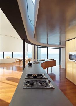 A sliver of skylight follows the curve of the kitchen’s bead-blasted steel counter. The interior millwork is all rift-sawn white oak.