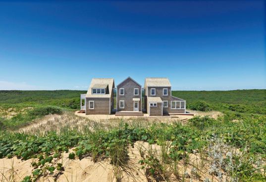 Viewed from atop the oceanfront dune the house separates into three connected pavilions.
