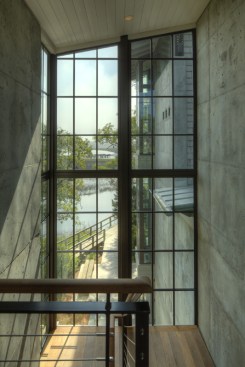 Steel-framed windows form the home's connective tissue, capturing pastoral scenery and natural light in between the concrete walls.