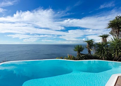 The pool wall forms a bright line between the swimming vessel above and the sea below.