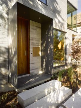 A plate steel frame at the front entry comprises both canopy and stoop. LED lighting is recessed into the top.