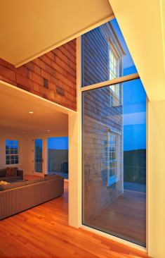 Floor-to-ceiling glass walls highlight the shingled exterior surfaces that extend through the interior.