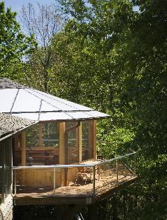 The roofing material is a combination of asphalt shingles (to match the existing shingles) and translucent polycarbonate panels, to transmit a glow of filtered natural daylight and minimize the loss of natural light in the now-enclosed kitchen and dining room.