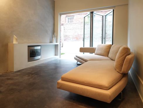 The family room in the rear of the revamped row house spills out into the small backyard via a series of folding glass doors. This space originally was occupied by the kitchen.   2011 Remodeling Design Awards (September)  Whole-House Remodeling $250,000 – $500,000  Kube Architecture, Washington, D.C.