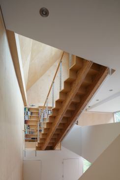 Sokol opened the three-story stairwell and aligned it with large windows and skylights. To save on cost and to integrate the stair with the interior spaces, Sokol designed a "distorted spiral drywall railing that winds down the entire stair."