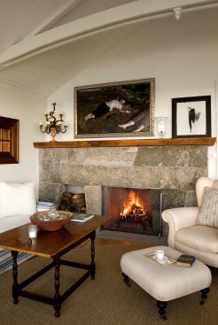 A stone fireplace with clean lines and a quadrilateral cut-out for logs offers a stylish, modern update to a beloved classic. Project: Maine Seaside House, Bar Harbor, Maine; Architect: Barnes Vanze Architects, Washington, D.C.; Builder: Classical Endeavors, Ellsworth, Maine