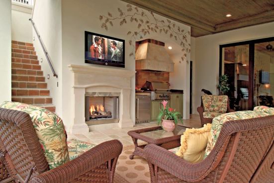 INSIDE OUT: The back elevation is anchored by stacked loggias, both of which feature kitchens. The downstairs loggia also has a fireplace and TV, as well as convenient access to the family room and a full bath inside, behind the kitchen setup.