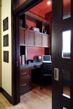 Dark wood built-ins lend a luxurious and stately feel to this home office, while a glass-paneled door and transom window keep it from feeling dim or isolated. Project: Pemberley, Ada, Mich.; Architect: Visbeen Architects, Chicago; Builder: Jeff Segard, Grandville, Mich.