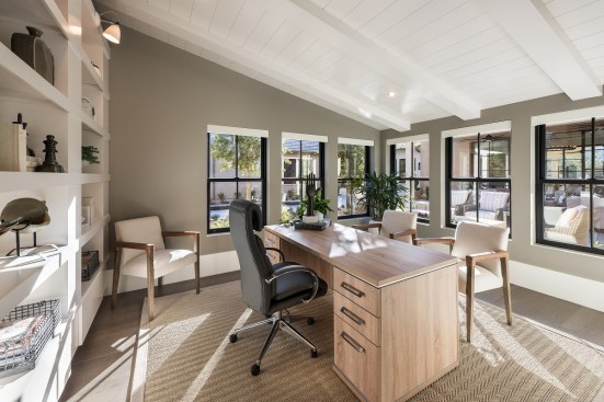 In Scottsdale, Arizona, Camelot Homes’ White Horse Plan 9502 Cheval office includes ample natural light with an open shelving backdrop.
