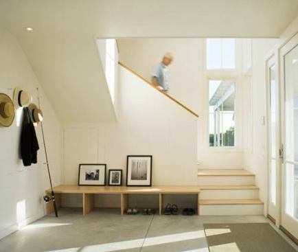 A flood of natural light and a deep, low-slung bench that accommodates shoe changes and artwork give this entryway a comfortable feel, while separated from main living space. Project: Barker House, Block Island, Rhode Island; Architect: Estes/Twombly Architects, Newport, Rhode Island; Builder: Highland Builders, Tiverton, Rhode Island