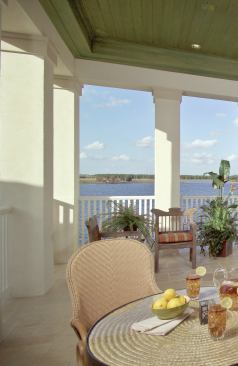 LOOKOUT LOUNGE: The upstairs loggia, complete with an outdoor kitchen and plenty of seating area at and around the bar, provides an unobstructed porch to view the lake on one side and the pool terrace on another.