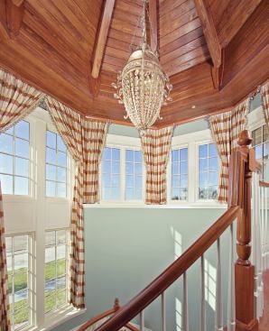 SKY'S THE LIMIT: A ring of windows at the top of the main stair tower brings light into the second story and the foyer below. As the community matures, there will be a pleasing view to the man-made lake out front and the neighbors beyond from this lookout.
