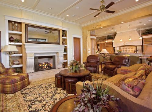 HARDY HEARTH: Flanked by tall bookshelves, the wide fireplace and precast stone surround and mantle break up the long wall of the garage behind it, offering family and friends a pleasant touch in the family room.