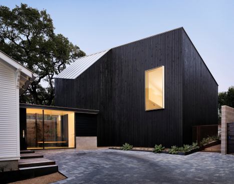 The addition, a black block that contrasts with the original bungalow's white exterior, more than doubles the size of the house.