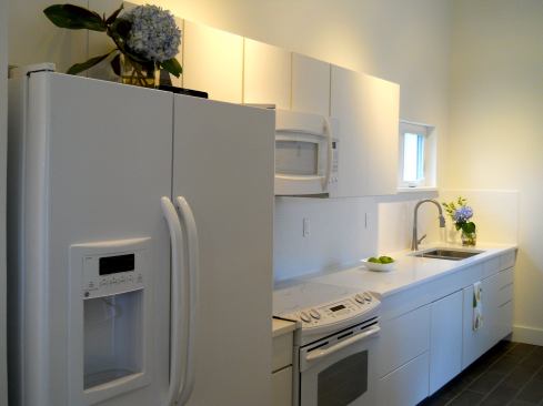 A small kitchen is laid out to provide a modicum of privacy to the homeowner. The same is true of the bedrooms, one of which has direct access to one of the bathrooms.