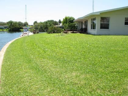 This before photo shows the home's small windows and how original back yard didn't take advantage of the river.