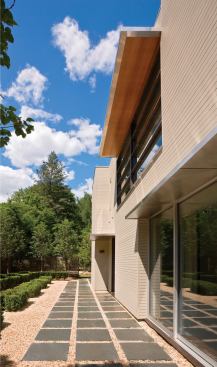 A cedar-slat fence at the driveway's head controls access to the side courtyard.