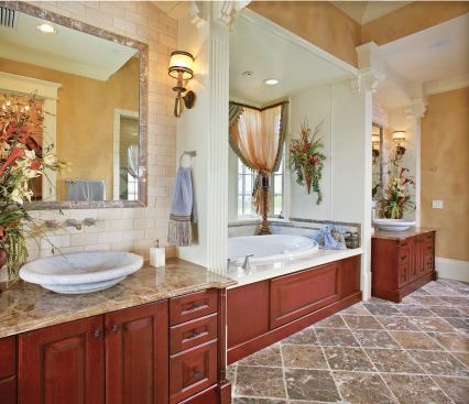 GREAT LENGTHS: The master bath travels along the the length of the home's side elevation, with luxury features and products on both walls. Private vanities flank a jetted overflow tub, balanced across the way by a generous, two-person shower and the enclosed water-closet.