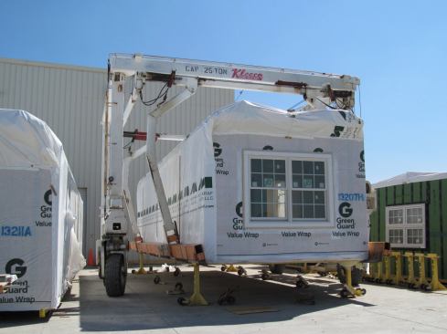Once a module is completed, it is stored outside the factory, usually for a few weeks. When the module is ready to be shipped, it’s moved and hoisted onto a flatbed by this mobile crane.
