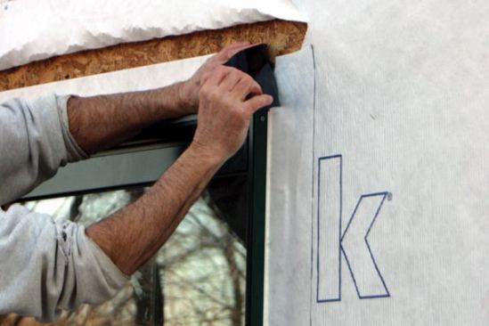... lapping it over the top of the jamb flashings. 
Note: Applying the head flashing directly to the sheathing provides another level of protection. If any moisture were to find its way behind the housewrap and seep down to the window, it would encounter the head flashing and be directed over the windowhead flange, not behind it.