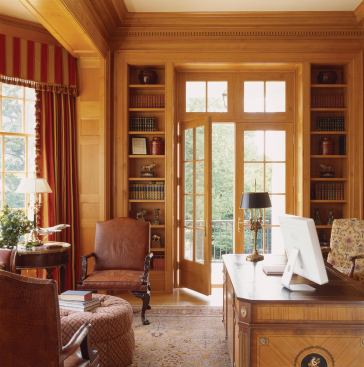 The wood-lined library feels light and airy, thanks to transom windows, French doors, and a large bay.