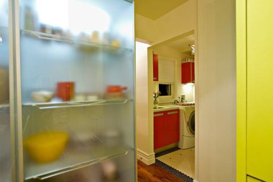 From the double pantry (sliding doors in acid-etched glass), a peek into the adjoining laundry area. Cabinets there are Arclinea's "Rosso Paprika" -- a complementary dash of color and function.