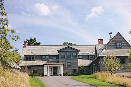 The porch and stair tower signal the entrance. The light-colored entryway mixes classical portico with farmhouse porch.