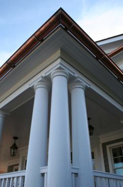 At the front entryway, Tuscan columns are ganged in threes.
