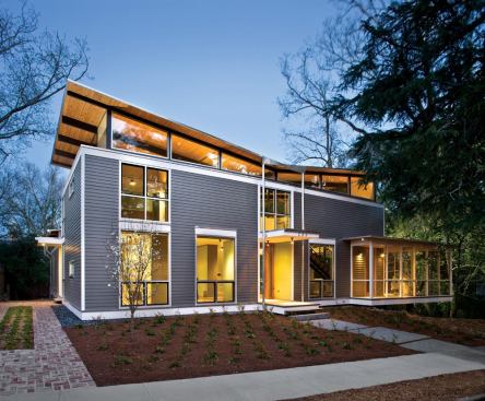 A center-sloping butterfly roof facilitates rainwater catchment while serving as a mounting platform for the house's photovoltaic array.