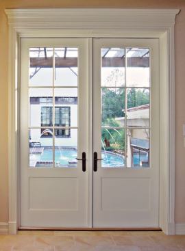 SWING KING: Architect Series out-swing patio doors from Pella Windows & Doors maximize views and bring in light. Shown here in the den, the 8-foot doors feature grilles with traditional high-definition profiles permanently bonded to the inside and outside of energy-efficient glass to meet Celebration's design codes. Solid pine grilles are bonded to the interior, while the exterior is protected with weather-resistant brown aluminum cladding. www.pella.com.