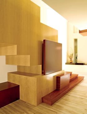 Architect Cathi House relied on rugged, exquisitely detailed woods to bring her staircase design to life. The dark red of Santos mahogany graces the steps and cutout accents. The staircase's underside is fashioned primarily from golden anigre.