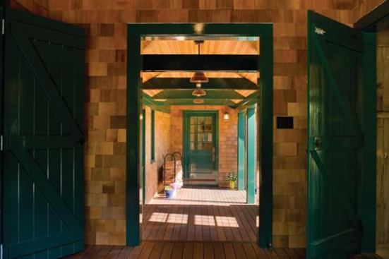 This covered walkway links the main house with the sheds and makes a strong statement with exposed beams and matching doors painted a bold green. Project: River Point House, South Coast, Mass.; Architect: Albert, Righter & Tittman, Boston; Builder: Roger Wilkie Builder, Tiverton, R.I.