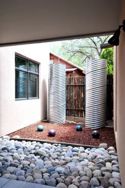 The water catchment system consists of two vertical culvert cisterns that hold 300 gallons of water each from the winter rains. A courtyard separates the detached studio from the rest of the house.