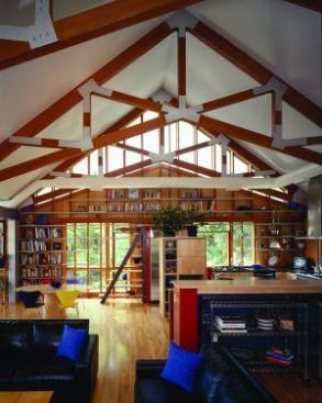 The existing studs and gable ends of the home's south elevation were stripped and repurposed to form a wall of exposed bookshelves.Architect: Reader Swartz Builder: David L. Goode