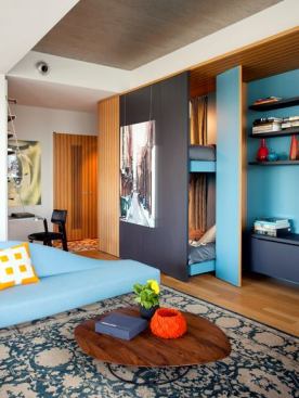 Hutker designed a multipurpose cabinet with movable pieces that house a bookshelf, AV equipment, and bunk beds for the kids or guests.