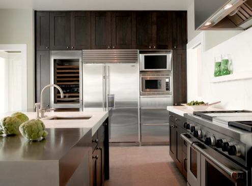 Materials include dark-stained rift-cut oak cabinets, counters and shelves of Calcutta marble, a center island braced by nickel-plated steel, and flamed French limestone floors. Interior design was by Jennifer Youngblood and Jeff Eckmann.