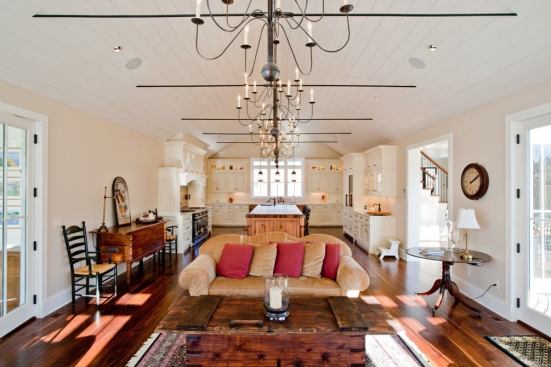 The kitchen and living areas are integrated as a single Great Room under a soaring plank-clad ceiling on one side of the house's central entry and circulation area.