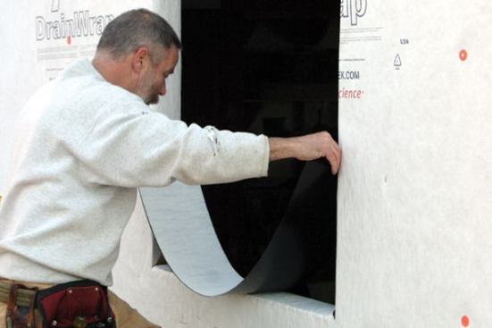 After removing the release paper, I make sure the membrane is centered in the opening... 
Note: Flashing membranes are meant to be installed at temperatures of 45 degrees or above. In colder weather, I keep the flashing in a warm place and cut pieces as I need them.