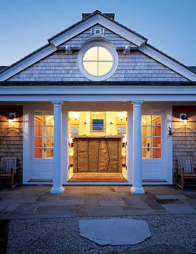 The imposing granite fireplace, visible from the house's front entry, anchors the living room.