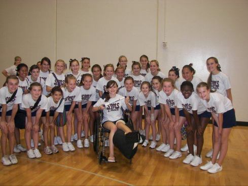 Emily Huddleston, still in a wheelchair after surgery, poses for a group photo with the rest of the South Middle School cheerleading squad.