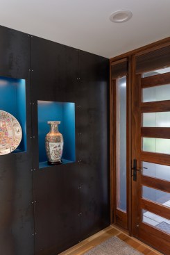 The steel wall outside pierces the facade to reappear in the foyer.