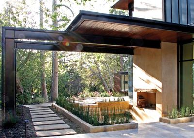 The spacious 8,000-square-foot home has a decidedly Japanese influence with low horizontal planes and a natural palette that creates an interplay of textures. The structural metal framing is left exposed while trowel stucco and stained cedar siding add warmth.