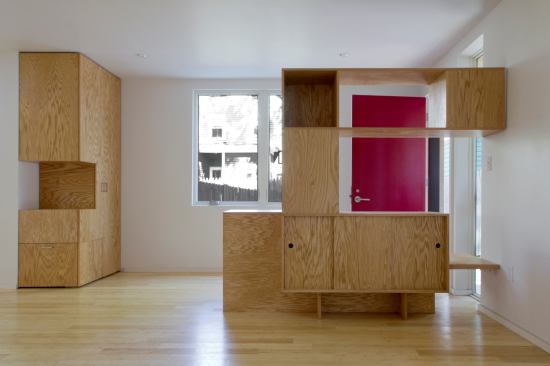 Custom plywood cabinetry throughout the home, including the entry foyer, warms the space and provides ample storage.