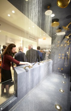 An attendee tests the shower bay at the grand opening of the KOHLER Experience Center in New York City.