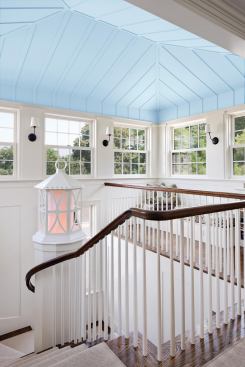 A band of windows floods the stair tower and second-floor hall with light, and a tent-like ceiling caps the space. The railing wraps without newel posts.