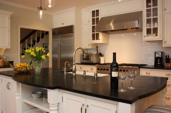 This farmhouse had received several updates and renova-
tions over the years. However, the floor plan was conflict-
ing amongst the kitchen, laundry, mudroom, and powder 
room. A complete reorganization of the first floor was 
achieved through multiple structural changes that al-
lowed for a larger kitchen and created better flow be-
tween adjacent rooms. The kitchen includes custom 
painted cabinetry, a farmhouse style sink, and soapstone 
countertops. A commercial size Viking range, hood, and 
Sub Zero refrigerator bring a theme of stainless steel to 
the kitchen which is accentuated by brushed nickel hard-
ware and island faucet. Specialty lighting, glass door 
cabinets, and a grand, eight foot island are just a few of 
the features that make this kitchen stunning.