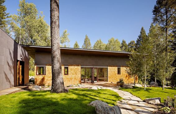 A separate garage, covered in the same fireproof bonderized steel panels that clad the upper portion of the guest house.
